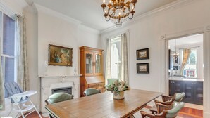 A dining room with a wooden table, green chairs, a chandelier, and a fireplace. - Home 2 Mi to Dtwn St Louis: Great for Families! (St. Louis)