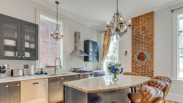 A modern kitchen with stainless steel appliances, a large island, and leather chairs. - Home 2 Mi to Dtwn St Louis: Great for Families! (St. Louis)