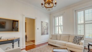 A spacious living room with a beige sofa, a wooden coffee table, and a chandelier. - Home 2 Mi to Dtwn St Louis: Great for Families! (St. Louis)