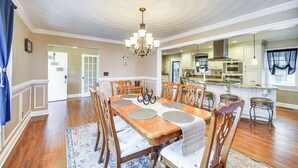 A dining room with a wooden table, chairs, and a chandelier. - Waterfront Home w/ Deck & Yard in Hampton! (Hampton)