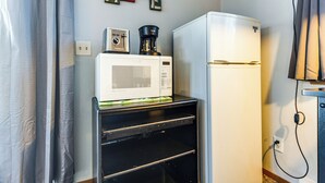 Une cuisine équipée d’un four à micro-ondes, d’une machine à café et d’un réfrigérateur.