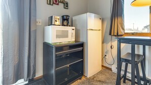 Une petite cuisine équipée d’un four à micro-ondes, d’une machine à café et d’un réfrigérateur.
