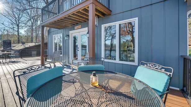 A deck with outdoor furniture, a table, and chairs. - Private Boat Dock: Troutman Home on the Water! (Troutman)