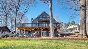 A large, two-story house with a balcony, surrounded by trees and a grassy yard. - Private Boat Dock: Troutman Home on the Water! (Troutman)