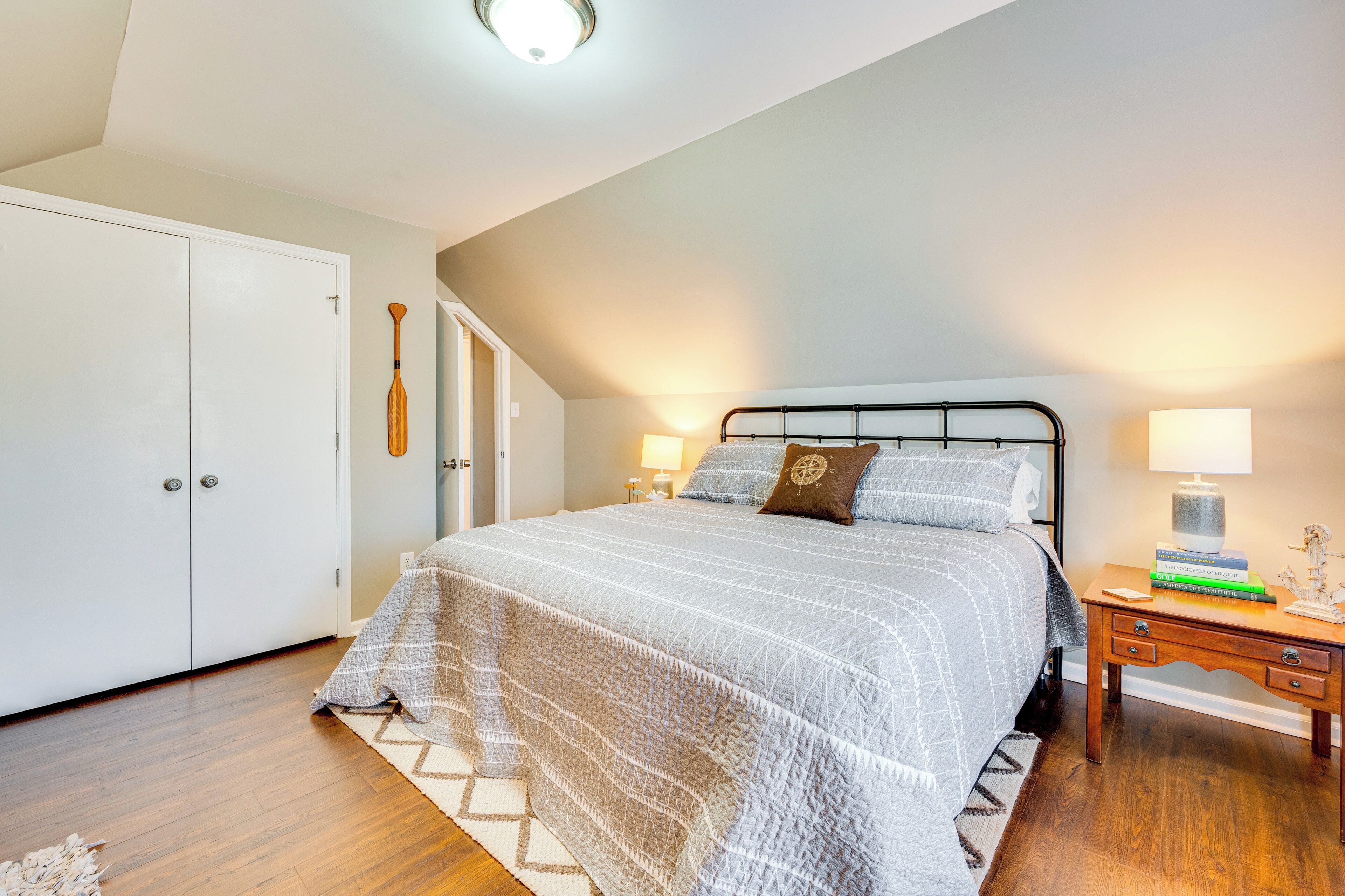 Ein Schlafzimmer mit Bett, Nachttischen, einem Kleiderschrank und einer Deckenleuchte.