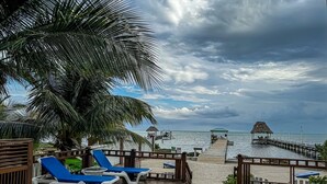 A pool area with lounge chairs, a wooden deck, and a view of the ocean. - La Perla Azul Beach House (San Pedro)