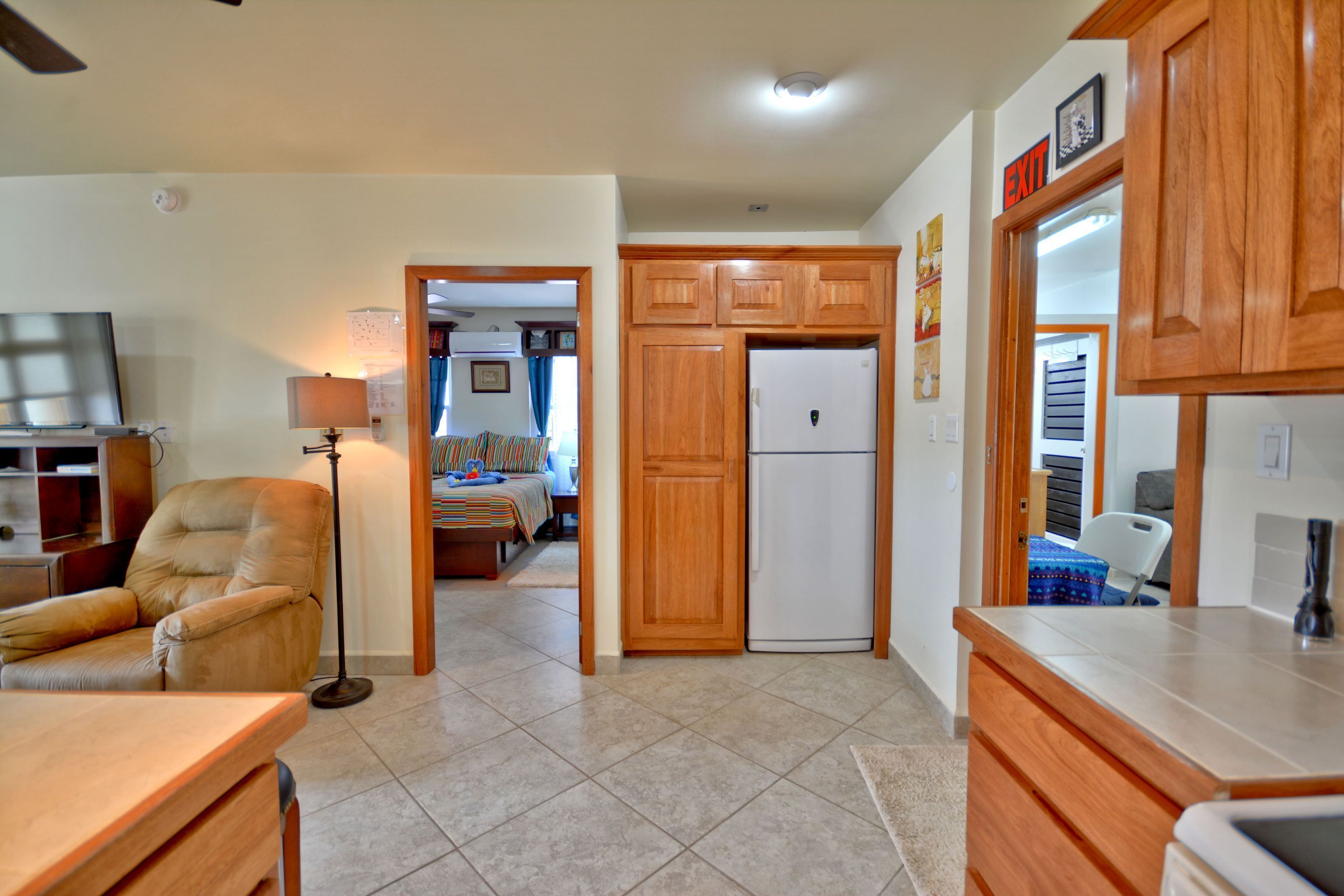A spacious kitchen with wooden cabinets, a refrigerator, and a dining area with a table and chairs.