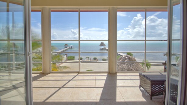 A balcony with a view of the ocean and a pier. - La Perla Azul Beach House (San Pedro)