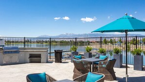 An outdoor patio with a grill, seating, and a view of a lake and mountains. - Amazing Water View w Jacuzzi Sky Lounge (Sparks)