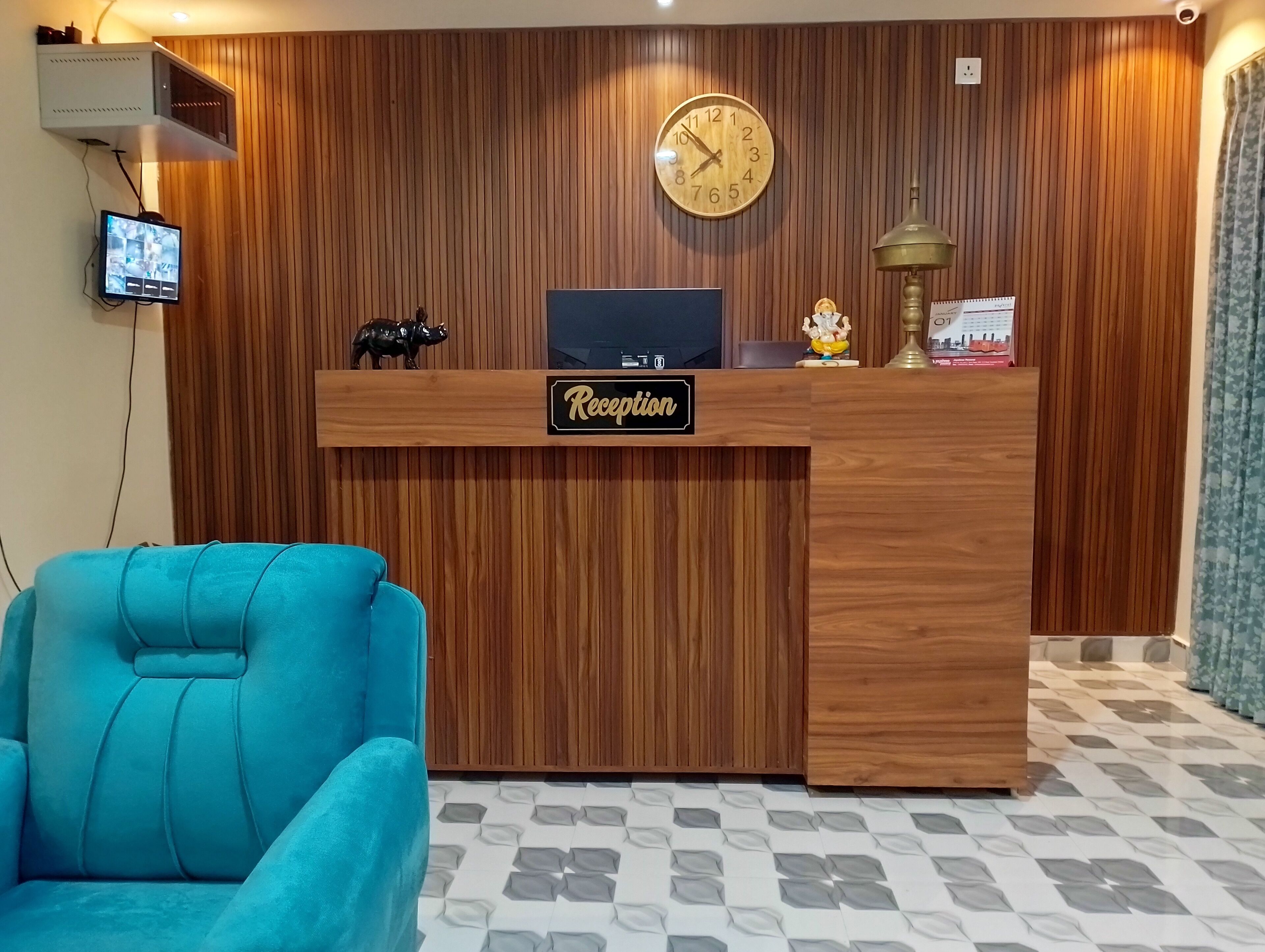 A reception desk with a clock, a television, and a statue.