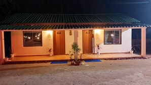 A two-story building with a tiled roof, a reception desk, and a sign indicating a guest room. - HIYAS RETREAT (Sonapur)
