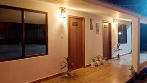 A hotel corridor with wooden flooring, potted plants, and doors labeled "Executive Villa". - HIYAS RETREAT (Sonapur)