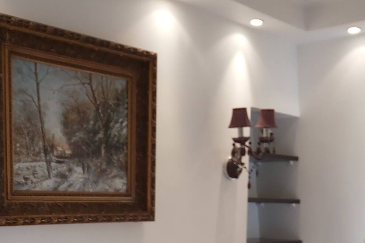 Ein Schlafzimmer mit einem Bett, einem Bild an der Wand und eingebauten Regalen.