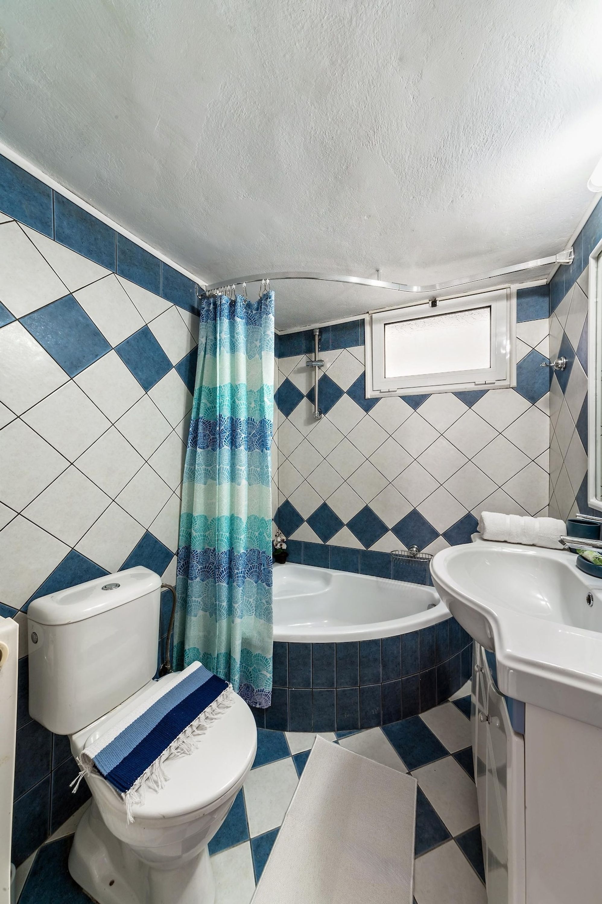 A bathroom with a toilet, bathtub, and sink.