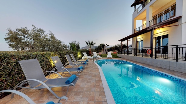 A poolside area with lounge chairs and a swimming pool. - Villa Angelika Two-storey House With Pool for 7 (Hersonissos)