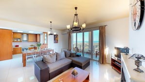 A modern living room with a sofa, coffee table, and dining area. - Villa Angelika Two-storey House With Pool for 7 (Hersonissos)