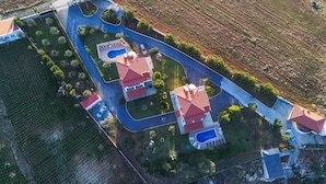 An aerial view of a residential area with multiple houses, a swimming pool, and a well-maintained garden. - Villa Angelika Two-storey House With Pool for 7 (Hersonissos)