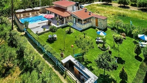 A residential property with a swimming pool, outdoor seating, and a well-maintained garden. - Villa Kalouas Private Pool (Malevizi)