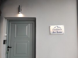 Una puerta con un ojo de cerradura y un cerrojo, una luz empotrada encima y un cartel que dice "Endikits Art Home".