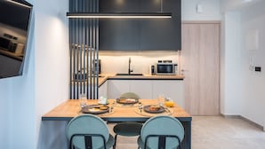 Una cocina moderna con una mesa de comedor de madera, dos sillas y un microondas integrado.