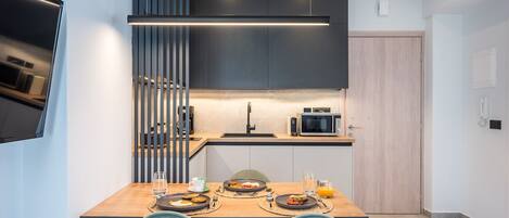 Una cocina moderna con una mesa de comedor de madera, dos sillas y un microondas integrado.