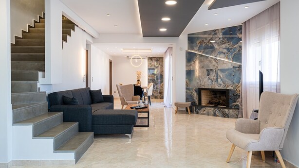 A modern living room with a staircase, a fireplace, and a seating area. - Villa Marie Nicol Private Pool (Malevizi)