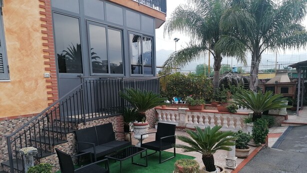A patio area with outdoor seating, a staircase, and potted plants.