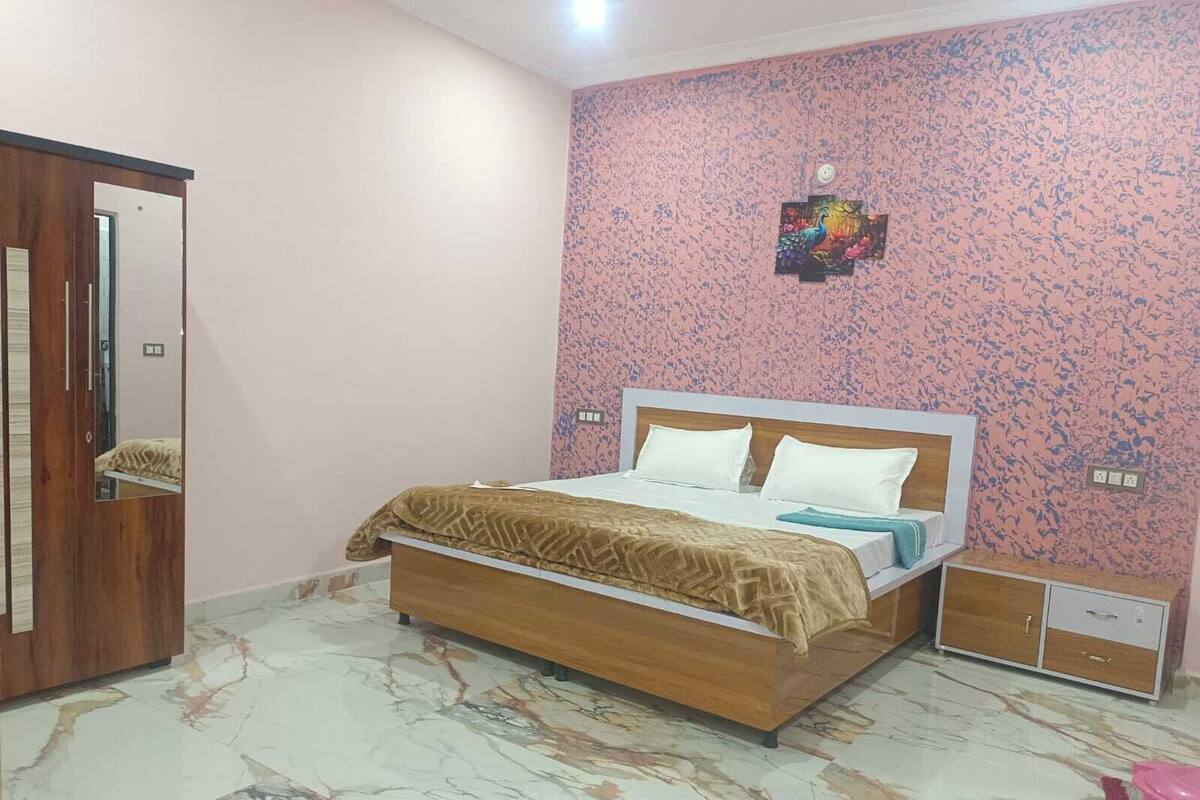 Un dormitorio con una cama, un armario y un pequeño aparador.