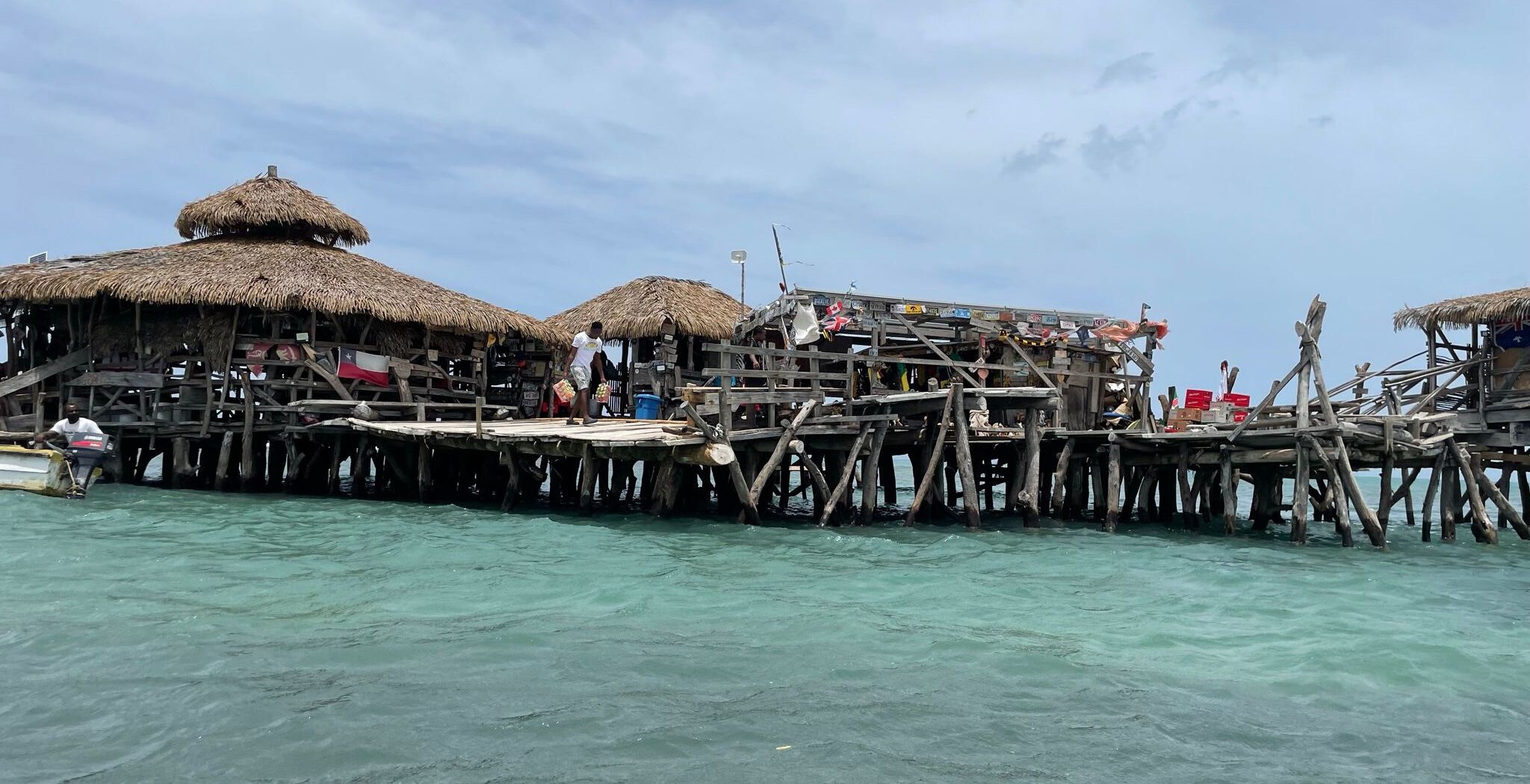 Estructura de madera con techos de paja sobre el agua, probablemente un resort u alojamiento.