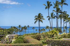 A tropical resort with palm trees, a view of the ocean, and well-maintained gardens. - Wailea Elua, #2107 2 Bedroom Condo (Kihei)