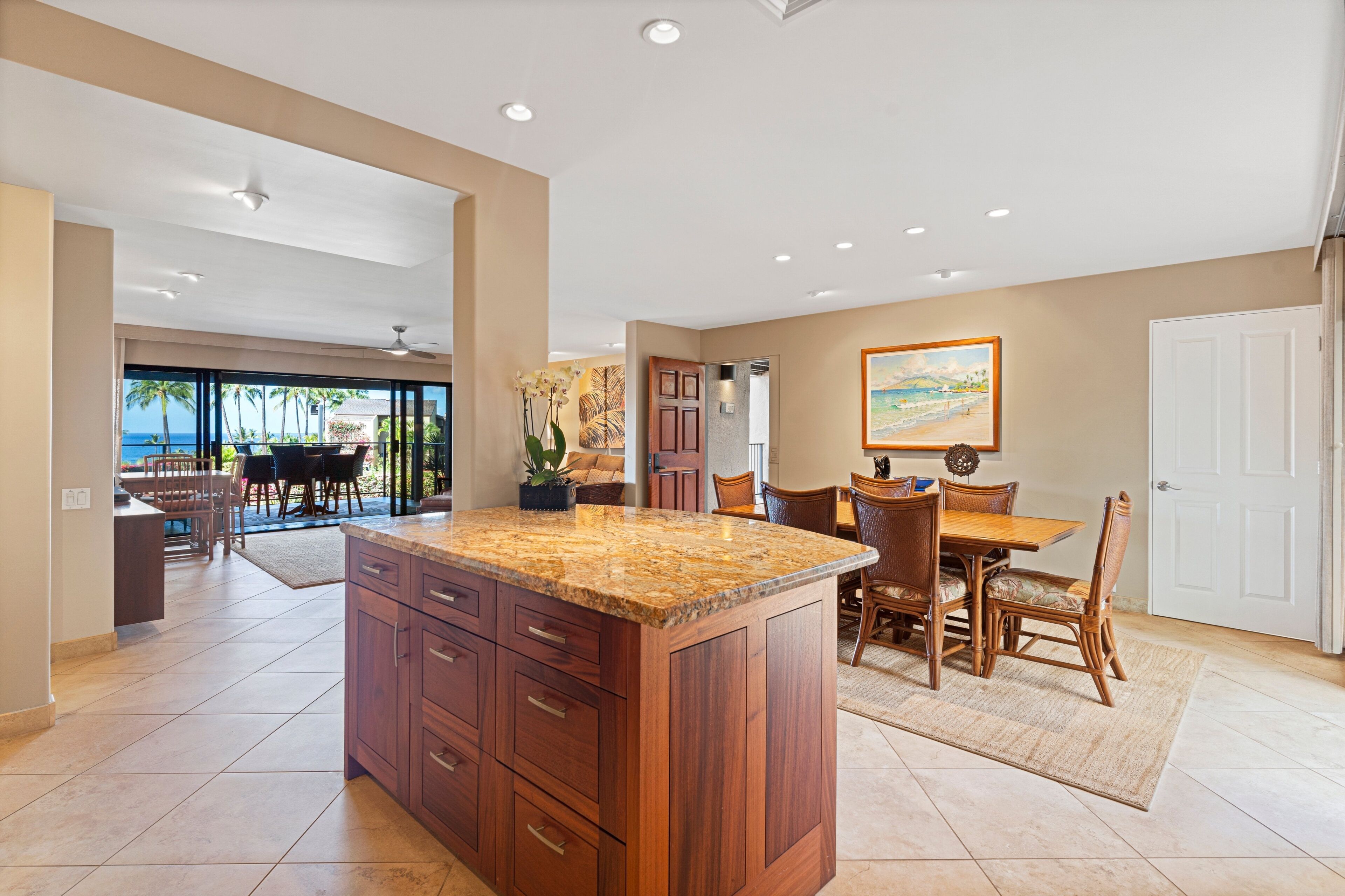 A spacious kitchen with a large island, wooden cabinets, and a dining area with a table and chairs.