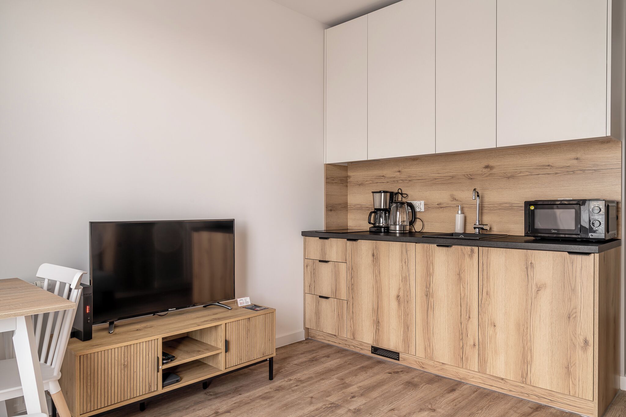 A compact kitchen with a wooden countertop, a built-in microwave, and a coffee maker.