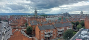 Un paysage urbain comprenant des bâtiments historiques, une tour imposante et un bâtiment moderne surmonté d’un dôme.