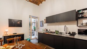Una cocina moderna con armarios oscuros, una mesa de comedor de madera y vistas al exterior.