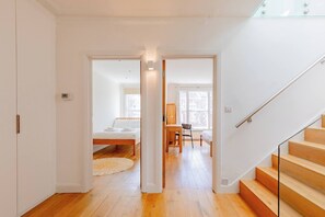 Un intérieur moderne avec un escalier en bois, un lit, un bureau et une chaise.