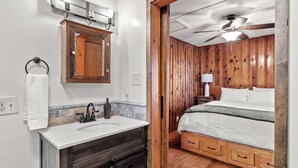 A bathroom with a wooden vanity, a sink, and a mirror. - Rockaway Retreat (Rockaway Beach)