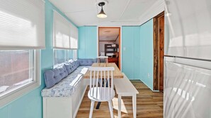 A room with a wooden bench, a white table, and a ceiling light. - Rockaway Retreat (Rockaway Beach)