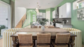A dining area with a wooden table, wicker chairs, and a central vase. - Vivid ATX Vibes | Pools. Personality. Pure Bliss! (Austin)