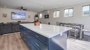 Una cocina moderna con una isla grande, armarios empotrados y un ventilador de techo.