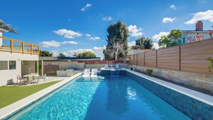 Una piscina con cubierta de madera y zona de patio.
