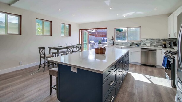 Una cocina moderna con una isla grande, electrodomésticos integrados y mucha luz natural.