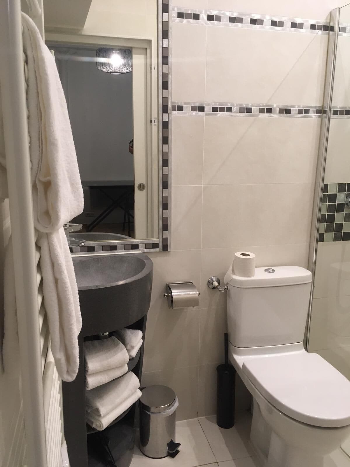 Une petite salle de bain comprenant un lavabo, des toilettes et un porte-serviettes.