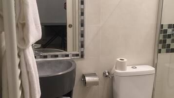 Une petite salle de bain comprenant un lavabo, des toilettes et un porte-serviettes.