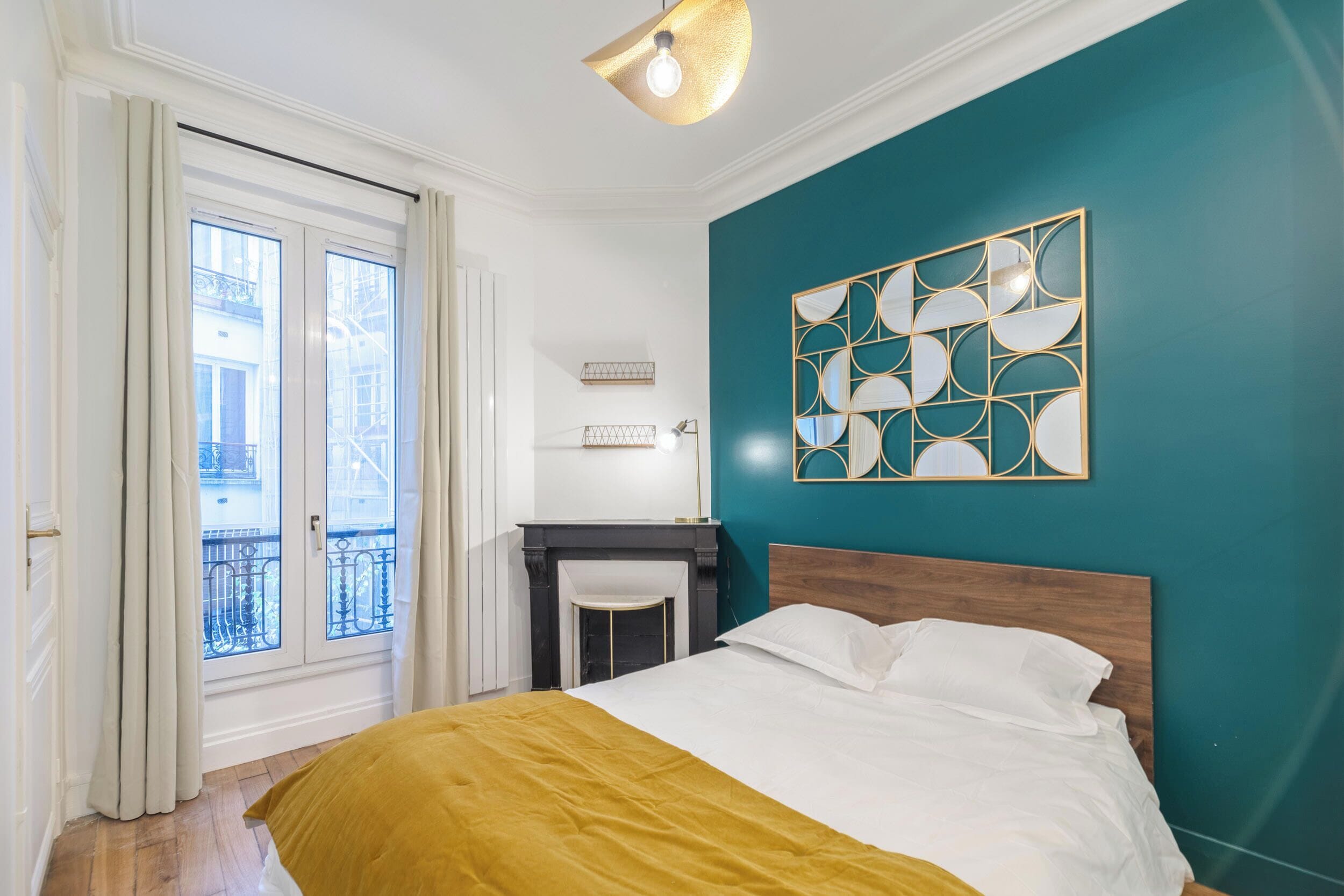 Ein Schlafzimmer mit einem Bett, einem Schreibtisch und einem fensterbepflanzten Fenster.