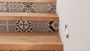 Un escalier avec des marches en bois et des carreaux décorés.