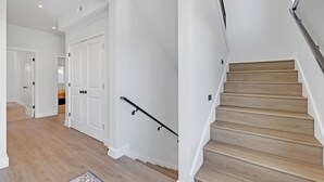 A staircase with wooden steps and a metal handrail, leading to a landing with white walls and a door. - Charming Mountain Retreat in the Heart of Frisco (Frisco)