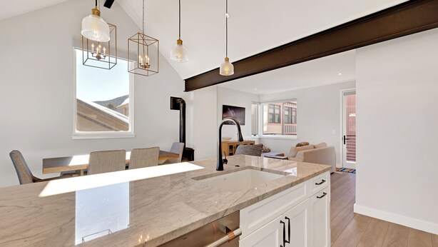 A modern kitchen with a large island, pendant lighting, and a view to the living area. - Charming Mountain Retreat in the Heart of Frisco (Frisco)