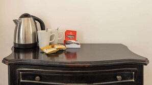 Un aparador negro con una tetera, dos tazas blancas y una caja de té Yorkshire Tea.