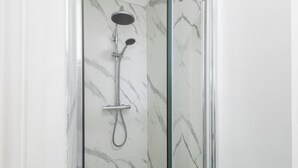 A glass-enclosed shower with a handheld showerhead and a wall-mounted rain showerhead. - Host & Stay | Grosmont at the Sandbeck (Whitby)