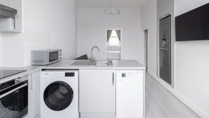 A modern kitchen with a microwave, washing machine, and a sink. - Host & Stay | Aberdeen Walk Apartment (Scarborough)
